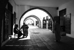 Image du Maroc Professionnelle de  Dans une rue des Habous, la succession des balèvres, moulure, arches, portiques et autres éléments décoratifs, projetent les visiteurs dans l’ardeur avec un élan de force et de fierté d’une époque révolue. Conçu par les architectes Auguste Cadet et Edmond Brion d’après l’ébauche d’un premier plan-masse dû à Albert Laprade, le quartier fait partie des endroits les plus pittoresques de Casablanca, il fut La construction n’avait commencé qu’après la première guerre mondiale. Situé près du Palais Royale, ce joyau architectural fait partie du patrimoine architectural de la ville, Samedi 8 Novembre 2008. Au centre le minaret de La mosquée Ben Youssef. (Photo / Abdeljalil Bounhar)
 